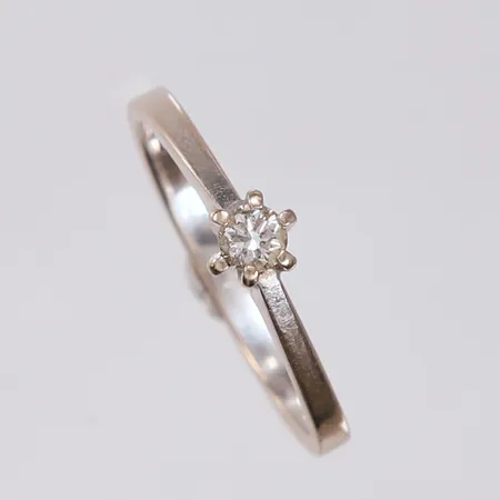 Ring med diamant ca. 0,15ct, ø 16,8mm, bredde 1-5mm, skjev klo og slitt rhodinering, 14K Vekt: 2,8 g