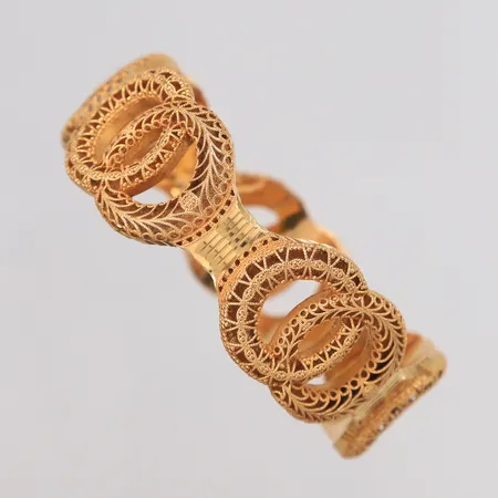 Armring, diameter 5,7 cm, bredde 21,5 mm, 21K. Vekt: 28,1 g Kontakt Lånekontoret for frakt
