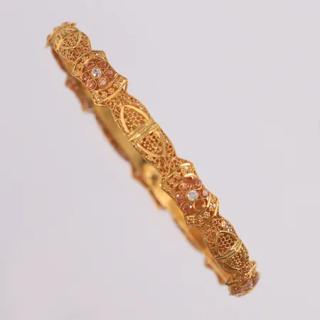 Armring med oransje og blanke stener, ø64mm, bredde 5-8mm, 22K Vekt: 12,3 g Kontakt Lånekontoret for frakt