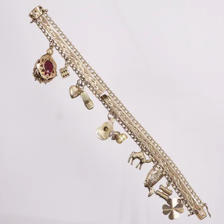 Armbånd med 8 charms, lengde 19cm, bredde 3-11mm, mangler en sikkerhetslås, lenke er ødelagt på ett sted, 18K.  Vekt: 32 g Kontakt Lånekontoret for frakt