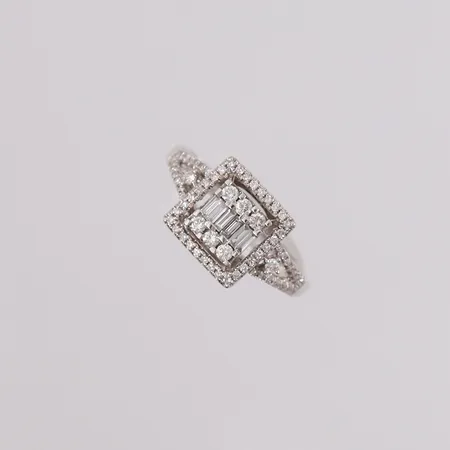 Ring med 74 diamanter (6 x ca. 0,025ct baguette-slipte, 8 x ca. 0,02ct og 60 små diamanter, ø,17mm, bredde 1,8- 9,8mm, hvitt gull, 14K Vekt: 2,6 g
