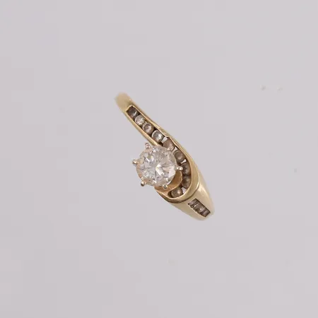 Ring med diamanter (1 x ca. 0,60ct og 13 x ca. 0,02ct), ø18,2mm, bredde 1,5- 8mm, defekt/sprekk øverst på ringen, 14K Vekt: 3,7 g