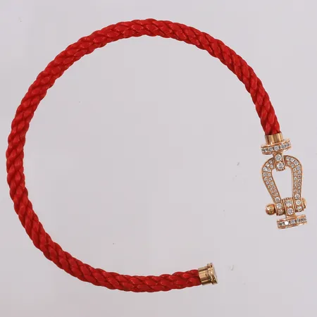 Armbånd med rød snor og 64 diamanter (totalt ca. 0,40ct), Fred Novelty Force 10 bracelet str. L, snr: 3281827, ø65mm, 18K, bruttovekt 10,6g, uten sertifikat/kvittering Kontakt Lånekontoret for frakt