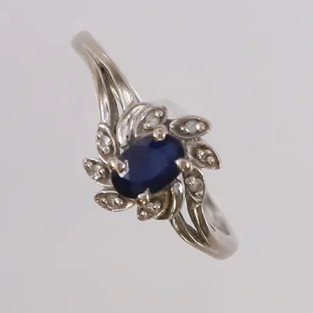 Ring med blå-sort sten og 8 små diamanter, ø17,9mm, bredde 1,5- 10,3mm, 14K Vekt: 2,9 g Kontakt Lånekontoret for frakt