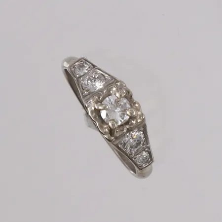 Ring med briljantslipte diamanter (1 x ca. 0,23ct + 2 x ca. 0,16ct + 2 x ca. 0,03ct), ø17,5mm, bredde 2,6- 6,8mm, hvitt gull, 14K Vekt: 4,1 g Kontakt Lånekontoret for frakt