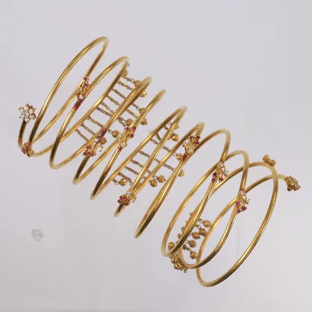 Armring/-bånd med fiolette og hvite/blanke stener, ø65mm, bredde 12cm, 22K Vekt: 105,6 g Kontakt Lånekontoret for frakt