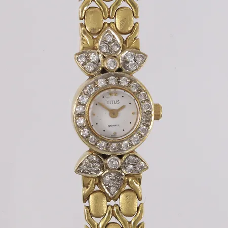 Titus armbåndsur med gull-lenke og briljantslipte diamanter (2 x ca. 0,02ct + 36 x ca. 0,01ct), quartz, boettnr. 06-0181A, baklokk i stål, behøver batteribytte, to diamanter har skader, 18K, bruttovekt 46,7g Vekt: 46,7 g Kontakt Lånekontoret for frakt