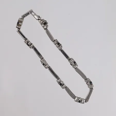 Armbånd med brlijantslipte diamanter (36 x ca. 0,02ct) og blå stener, lengde 18,5cm, bredde 3,4- 5,6mm, noe slitasje, hvitt gull, 18K Vekt: 16,4 g Kontakt Lånekontoret for frakt