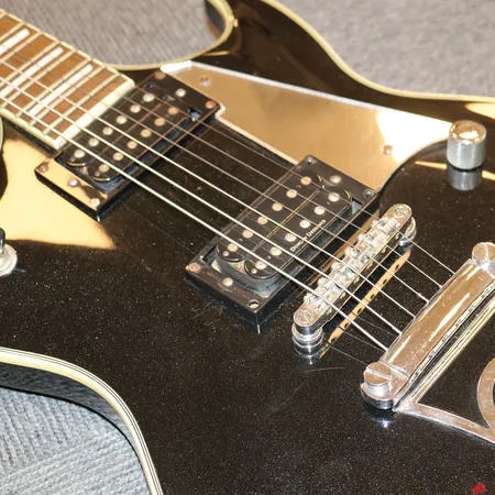 Silvertone Paul Stanley elektrisk gitar, svart/sølv. OBS!: En justeringsknapp sitter løst. Softbag medfølger. Vekt: 0 g Kontakt Lånekontoret for frakt