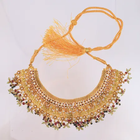 Halssmykke med fargede stener (én blank sten mangler) og snor, justerbar lengde, bredde 5,5 cm, 21K, bruttovekt 109,9 g. Kontakt Lånekontoret for frakt