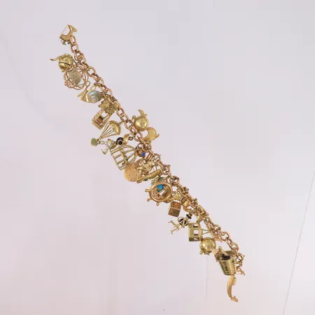 Armbånd med 28 charms, lengde 19cm, bredde 6,6- 40mm, 14K Vekt: 51,2 g Kontakt Lånekontoret for frakt