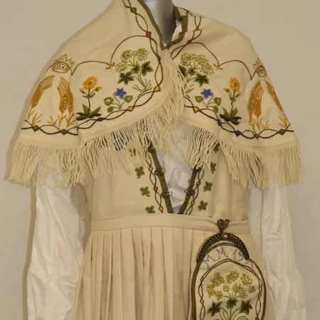 Rogalandsbunad med skjorte (bomull), sjal, veske, lue, belte, hårbånd, 1 par dobber, 1 sjalkjede, 1 par mansjettknapper, 2 søljer, 1 brystkjede, 2 hemper, ca strl L (muligheter for endring). Lengde ca 150 cm, liv ca 95 cm Kontakt Lånekontoret for frakt