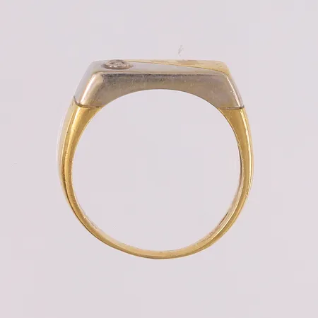 Ring med diamant (1 x ca. 0,04ct) på plate, to-farget, ø20,6mm, bredde 3- 8,6mm, 18K Vekt: 7,7 g Kontakt Lånekontoret for frakt