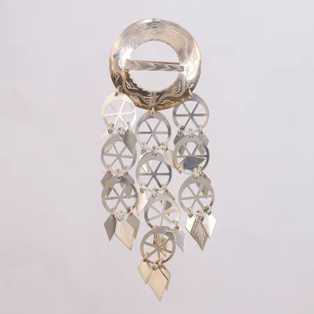 Bunadsølje, høyde ca 12cm, bredde 40mm, sannsynligvis til trøndelagsbunad, 925/1000 sterlingsølv.  Vekt: 16,3 g Kontakt Lånekontoret for frakt