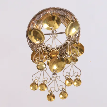 Bunadsølje, høyde ca 60mm, bredde ca 35mm, 830/1000 sølv. Vekt: 11,1 g Kontakt Lånekontoret for frakt