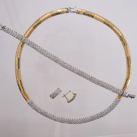 Smykkesett med klare stener, bestående av halskjede 45 cm bredde 7,1 mm, armbånd 19 cm bredde 7,1 cm, og øredobber 16x7,1 mm, 14K. Vekt: 64,3 g Kontakt Lånekontoret for frakt