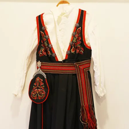 Øst-Telemark dame, forkle, sjorte veske, belte, halssølje, brystsølje, 1 par mansjettknapper, trenger rens. Kontakt Lånekontoret for frakt