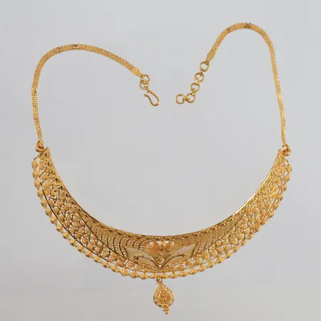 Halssmykke, lengde ca. 34cm, bredde 2,4- 48mm, noe ujevnt mønster, 22K Vekt: 24,3 g Kontakt Lånekontoret for frakt