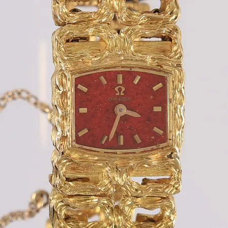 Armbåndsur i gull, Omega, trolig modell «Maille d'or» (designet av Albert Gilbert), merket 711.1344, rød urskive, manuell, urverket går, 18K i urkasse og lenke, bruttovekt 53,7g Kontakt Lånekontoret for frakt