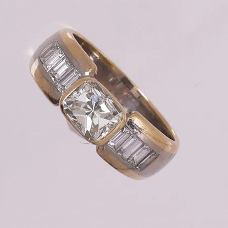 Ring med diamanter, 1 x ca 1,05 ct og 8 x baguettslipte 0,05 ct, to-farget, Ø 18 mm, bredde 6,4 mm, 18K Vekt: 7,9 g Kontakt Lånekontoret for frakt