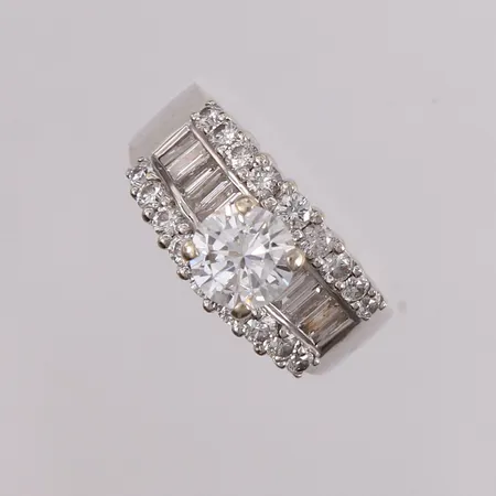 Ring med diamanter 1x ca 1,10ct, 18x ca 0,03ct og 10x ca 0,04 baguettslipte diamanter, ø17,50mm, bredde 4mm, 18K.  Vekt: 7,5 g Kontakt Lånekontoret for frakt