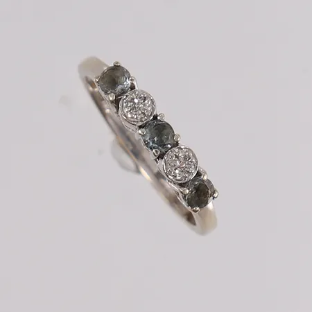 Ring med diamanter 8x ca 0,005ct og blå stener, ø17,25mm, bredde 2mm, 14K hvitt gull.  Vekt: 1,9 g Kontakt Lånekontoret for frakt