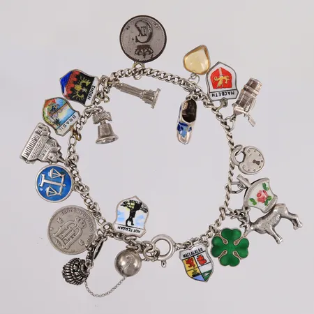 Armbånd med 20 charms, lengde ca 15,5cm, bredde ca 2mm, 830-925/1000 sølv.  Vekt: 31 g Kontakt Lånekontoret for frakt