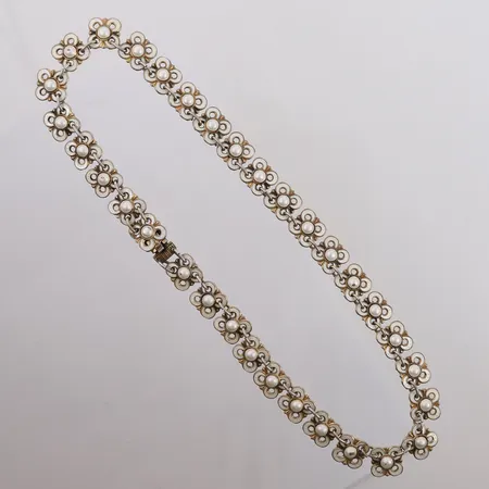 Halssmykke med hvit emalje og blomstermønster ("Quatrefoil"), designet av Willy Winnæs for David-Andersen, 1950-tallet, lengde 39cm, bredde 11mm, noe slitasje, 925S Vekt: 31,1 g Kontakt Lånekontoret for frakt
