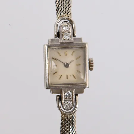 Armbåndsur i hvitt gull med diamanter (4 x ca. 0,05ct), 19x15mm, hvit urskive, ikke funksjonstestet, opptrekksmekanisme virker defekt, 14K (lenken er 18K), bruttovekt 20,9g Kontakt Lånekontoret for frakt