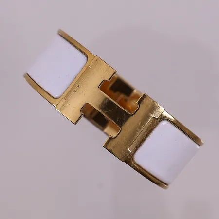 Armband Hermès Clic Clac H, gullfarge med hvit emalje, oval, serienr 5295516, Ø 55 mm, bredde 20 mm, kvittering Oslo 2020, støvtrekk,  ytterboks Kontakt Lånekontoret for frakt