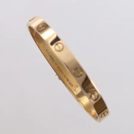Armbånd Cartier Love Bracelet, 18K, stl 17, ca 56x47,5mm, bredde ca 6mm, serienr ACZ812, 18K, noe riper, sertifikat Cartier London september 2014, skrutrekker, boks og yttereske. Nypris ca 100.000kr. Vekt: 32,2 g Kontakt Lånekontoret for frakt