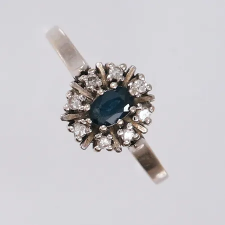 Ring med diamanter (8 x ca. 0,01ct) og blå sten, ø18mm, bredde 1- 10mm, 14K, bruttovekt 2,2g Vekt: 0 g Kontakt Lånekontoret for frakt