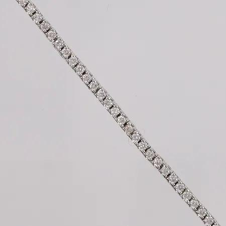 Tennisarmbånd med briljantslipte diamanter (totalt 1,00ct W / SI iht. sertifikat), lengde 18cm, bredde 1,7g, hvitt gull, 14K, bruttovekt 5,7g, diamantsertifikat og kvittering medfølger Kontakt Lånekontoret for frakt