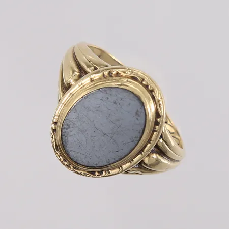 Ring med grå plate (trolig hematitt), ø19mm, bredde 2,4- 18,2mm, gravert, 14K, bruttovekt 4,2g Vekt: 0 g Kontakt Lånekontoret for frakt