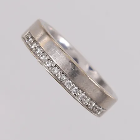 Ring med 15 stk. diamanter (totalt 0,15ct iht. gravering), ø17,6mm, bredde 5mm, gravert, hvitt gull, 14K, bruttovekt 7,3g Vekt: 0 g Kontakt Lånekontoret for frakt
