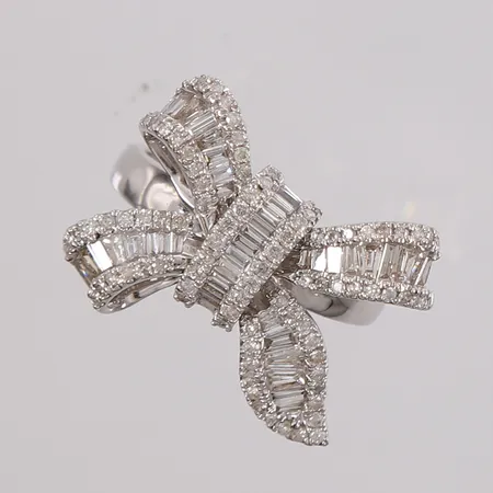 Ring sløyfe med briljantslipte og baguetteslipte diamanter (totalt 1,00ct iht. gravering), ø16,8mm, bredde 2,4- 16,8mm, hvitt gull, 18K, bruttovekt 4,6g Vekt: 0 g Kontakt Lånekontoret for frakt