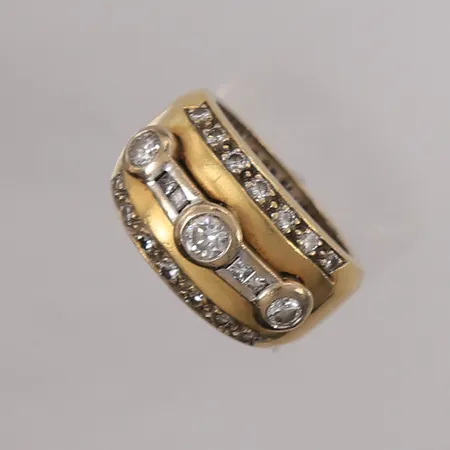 Ring med diamanter (1x ca 0,23ct, 2x ca 0,16ct og 18x ca 0,01ct), to-farget, ø16,75mm, bredde ca 5,6mm, 18K gull. Vekt: 15,1 g Kontakt Lånekontoret for frakt