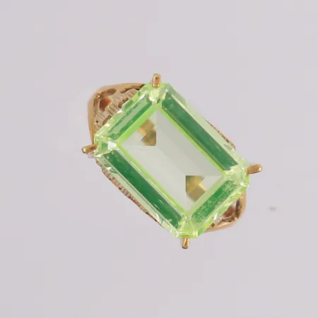 Ring med gul-grønn syntetisk spinell, ø17,8mm, bredde 1,8- 10mm, 14K Vekt: 3,4 g Kontakt Lånekontoret for frakt