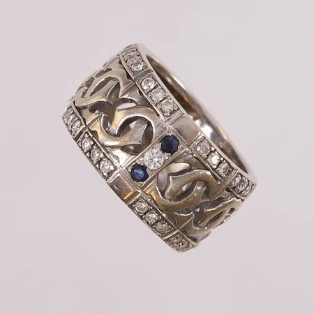 Ring med to blå stener og diamanter 54x ca 0,01ct, ø17mm, bredde 12mm, 14K hvittgull. Vekt: 9,6 g Kontakt Lånekontoret for frakt