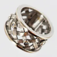 Ring med diamanter ca 5x ca 0,01ct, stl 16½, bredd 11mm, formgiven av Ole Lynggaard, vitguld, 18K. Finns för visning på Pantbanken Centralen Vikt: 10,3 g
