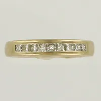 Ring med prinsesslipade diamanter 9xca 0,06ct totalt 0,56ct enligt gravyr, stl 16¾, bredd ca 3mm, vitguld, gravyr. 18K  Vikt: 6,9 g