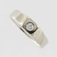 Ring med diamant ca 0,10ct, stl  20,½mm, bredd ca 4,4-6,5 mm, 14k vitguld  Vikt: 7,2 g