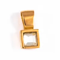 Berlock i 18K guld med en vit sten. Den är 11,7 mm lång inkl. fast ögla och väger 1,0g. Stämplad GFAB (Guldfynd) & 750. 