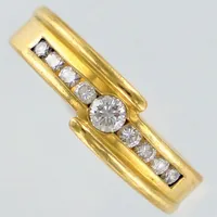 Ring med diamanter 1x ca 0,12ct och 8x ca 0,02ct, stl 16, bredd ca 3-6mm. 18K  Vikt: 6,3 g