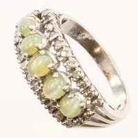 Ring med gröna stenar, troligen krysoberyll samt syntetiska och äkta diamanter, vitguld, stl 18½, bredd ca 9,5mm, 18K Vikt: 7,7 g