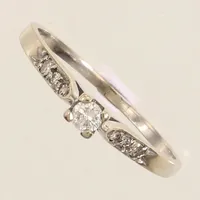 Ring vitguld med diamanter 1 x ca 0,10ct + 6 x ca 0,005-0,01ct, stl 18½, bredd ca 1-3mm, bör rodieras om, repigt sten, 18K  Vikt: 1,8 g