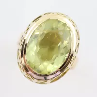 Ring med stor gulgrön sten något slitna kanter, stl 16¾ mm, bredd ca 4,2-20 mm, 18k  Vikt: 5,7 g