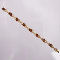 Armband med orange/bruna stenar, längd ca 18cm, bredd:8mm, 18K guld Vikt: 17 g
