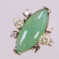Ring med grön sten, troligen jadeit och diamanter 2x ca 0,25ct piqué, en med nagg, 3x ca 0,03ct, stl 15¾, bredd ca 2,5-22mm, vitguld, en diamant saknas. 18K  Vikt: 5,2 g