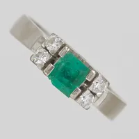 Ring, smaragd, 0,60ct enligt gravyr och 4 diamanter, 0,20ctv enligt gravyr, Ø19½, bredd: 4mm, smaragden har ytliga inneslutningar och nagg, vitguld, 18K Vikt: 6,3 g